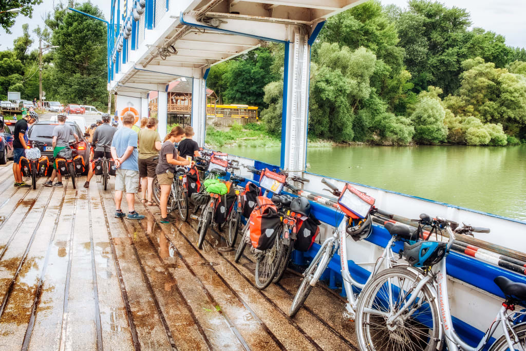 Gruppo di ciclisti sul un pontile lungo il Danubio con biciclette parcheggiate